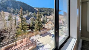Vista desde una ventana que da a un área residencial con casas, árboles y una montaña al fondo.