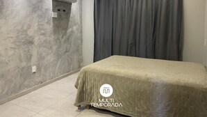 A bedroom with a bed, grey curtains, a wall-mounted air conditioner, and a tiled floor. - Refúgio Menegaz - Governador Celso Ramos - SC (Governador Celso Ramos)