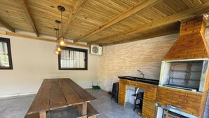 Una cocina rústica con una mesa de madera, un horno de ladrillo y un colgante de techo.