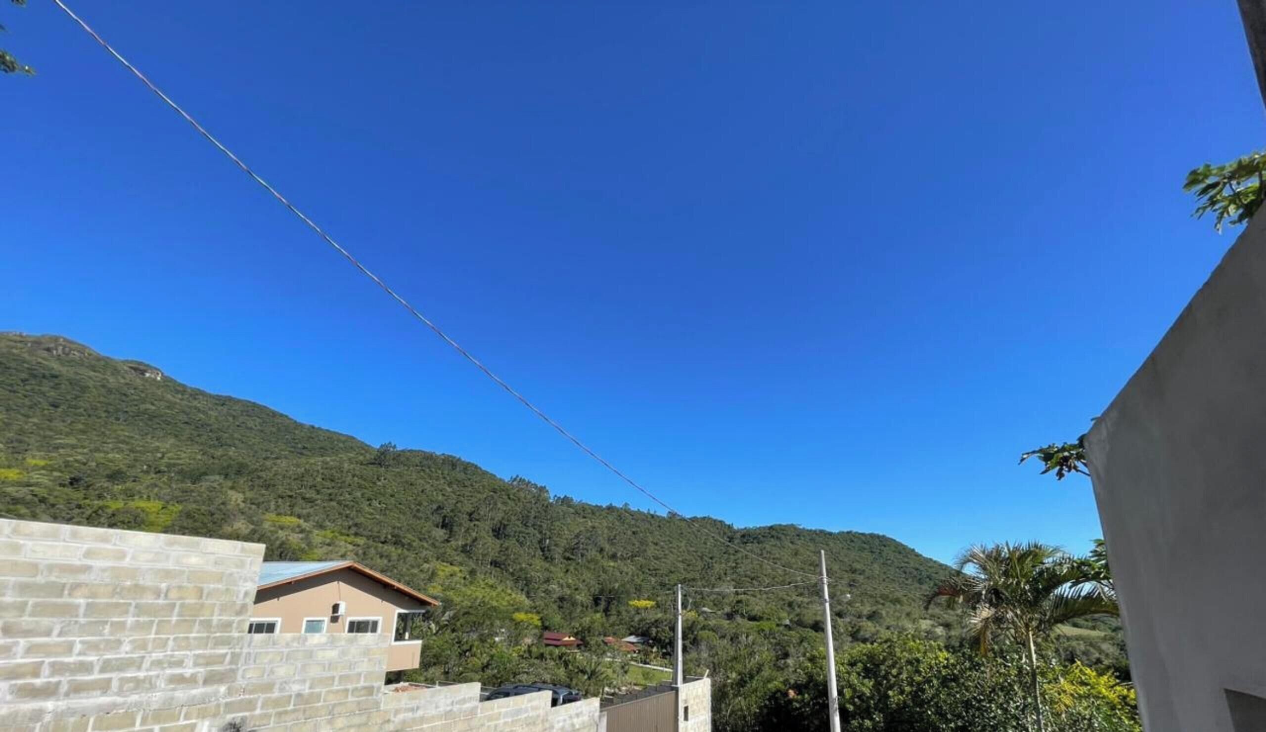 Un quartier résidentiel avec des maisons, un ciel d’un bleu éclatant et un paysage vallonné.