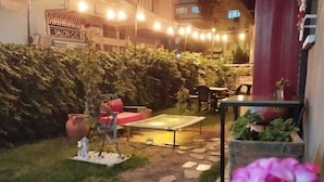 An outdoor patio area with string lights, a small table, chairs, and potted plants. - ROTA GEZGİN PANSİYON (Eskisehir)