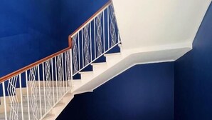 Una escalera de varios niveles con barandillas blancas y pasamanos de madera.
