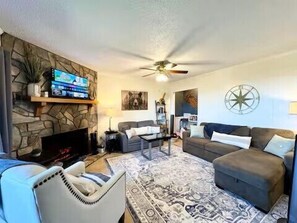 Smart TV, chimenea, mesa de ping pong, libros