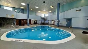 An indoor swimming pool with a tiled floor, surrounded by walls and columns, and a staircase leading to an upper level. - 2120  Hot tub, sauna & more resort amenities Beautifully remodeled, 1st-floor (Beech Mountain)