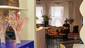 A modern hotel lobby with seating areas, a reception desk, and decorative plants. - P6 Antwerp (Antwerp)