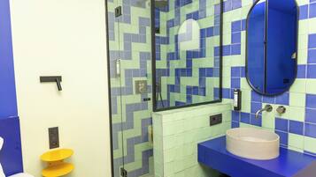 Un baño con ducha, lavamanos e inodoro.