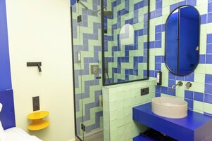 A bathroom with a shower, a sink, and a toilet.