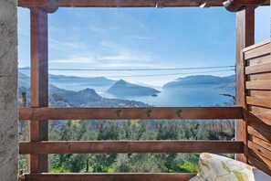 A wooden-framed window with a view of a mountainous landscape and a body of water. - Room 'Stanza 2' with Lake View, Wi-Fi and Air Conditioning (Marone)