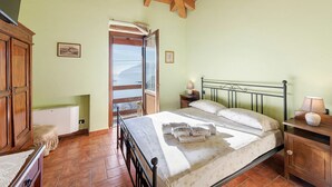 Un dormitorio con cama, cabecero de madera, mesitas de noche y ventana con vistas al exterior.