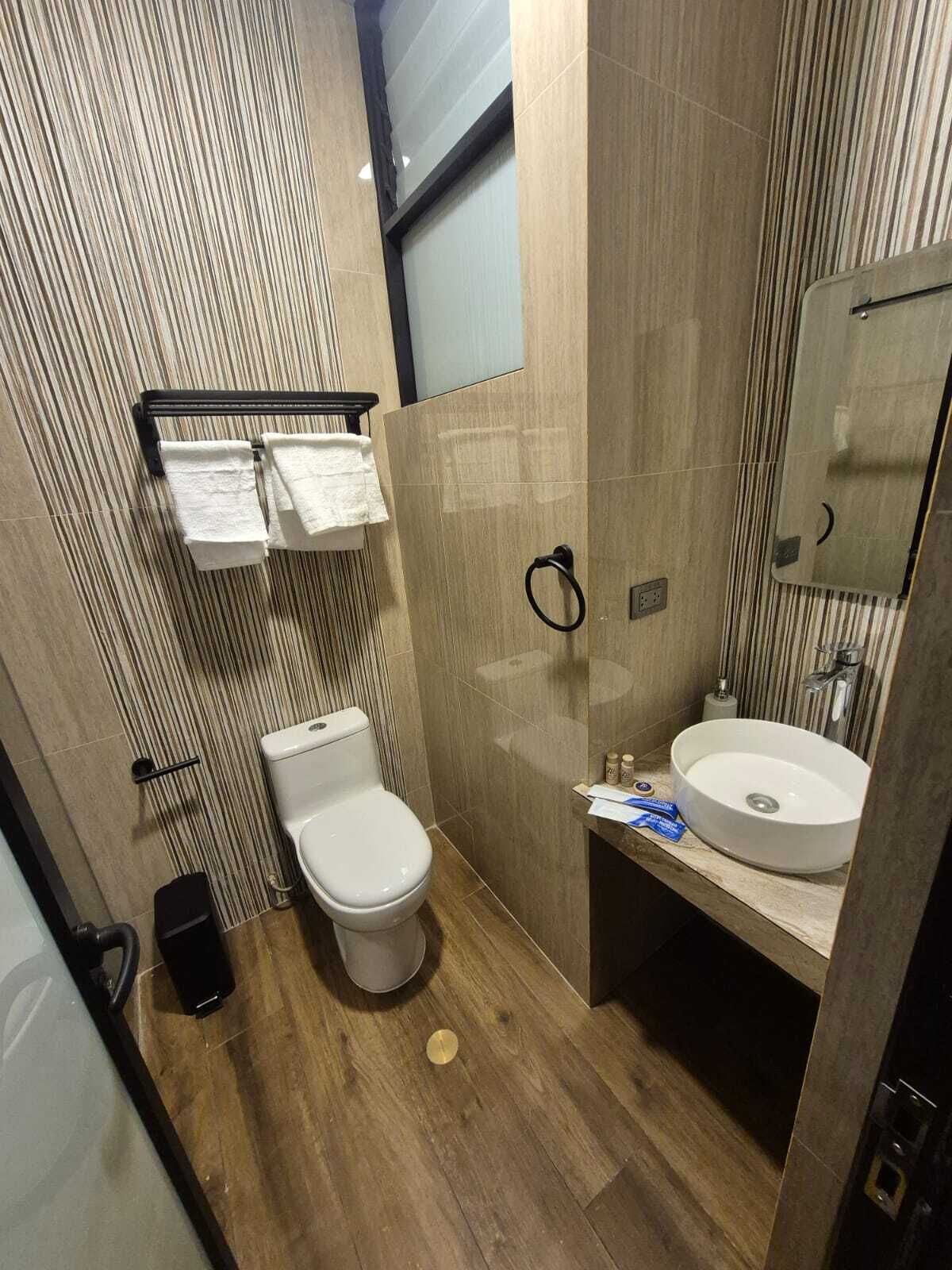 A modern bathroom with a toilet, sink, and towel rack.