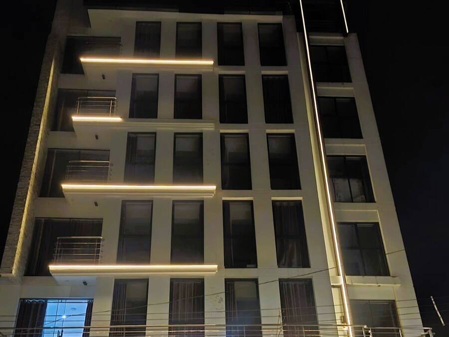 Un hotel de varios pisos con señalización iluminada que dice 'HOTEL & SUITE ZANIAH'.
