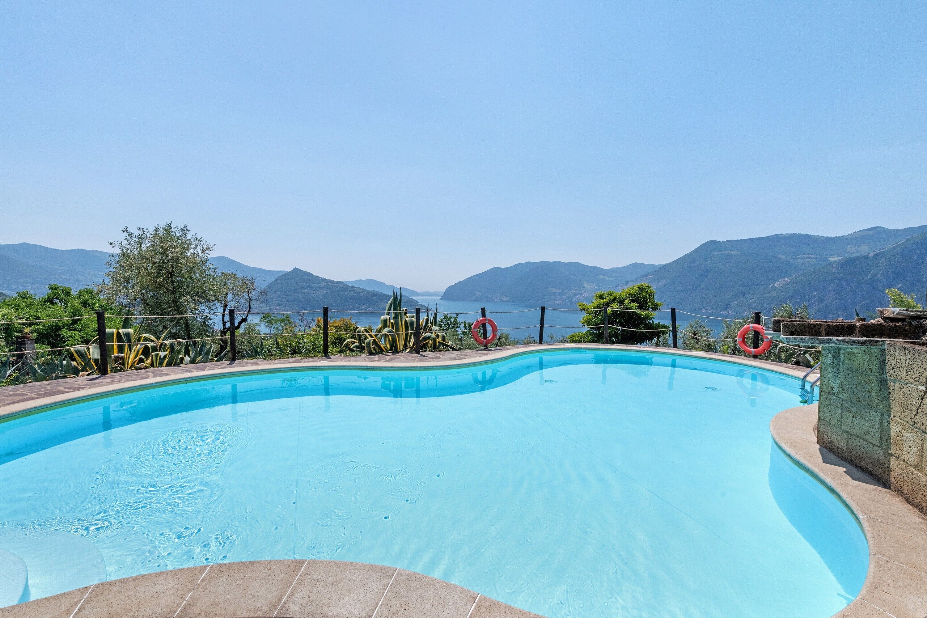 Piscina com vista para montanhas e um lago.