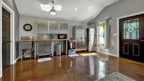 A spacious kitchen with a wooden countertop, stainless steel appliances, and a ceiling fan. - Quonset-Style Cabin & Sunset Patio Near Blue Hole (Wimberley)