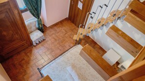 A wooden staircase with a handrail, a small bench, and a patterned rug on the floor. - Room 'Stanza 5' with Mountain View, Wi-Fi and Air Conditioning (Marone)