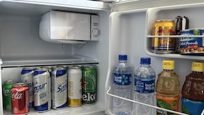 A refrigerator stocked with beverages including sodas, beer, and water. - City Tower Hotel (Ulaanbaatar)