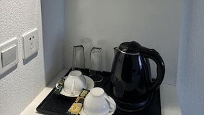 A black tray with a black coffee pot, two white cups, and a tea bag on a white countertop. - City Tower Hotel (Ulaanbaatar)