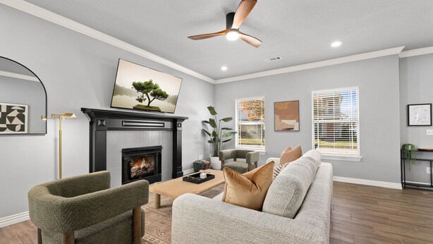 A living room with a fireplace, a sofa, a chair, a coffee table, and a ceiling fan. - Basecamp - 3 miles to DT (Fayetteville)