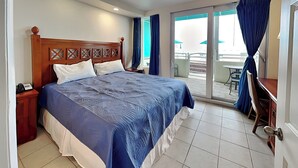 Una habitación de hotel con una cama grande, un escritorio y vistas al exterior.