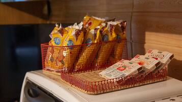 A kitchen with a red basket containing yellow packages and a white appliance.