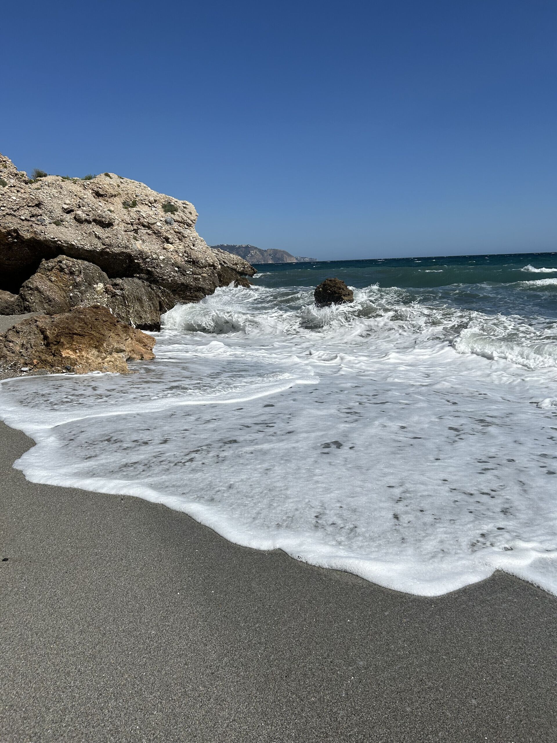 A rocky coastline with waves crashing onto the shore.