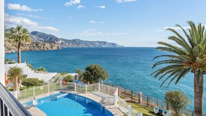 Una piscina con vistas al mar y a las montañas.