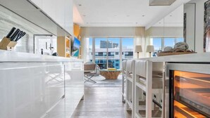 A modern kitchen with a central island, a dining area with a view, and a built-in oven. - Villa DecoBlu (Miami Beach)