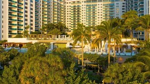 A hotel with multiple high-rise buildings, a pool area, and palm trees. - Villa DecoBlu (Miami Beach)