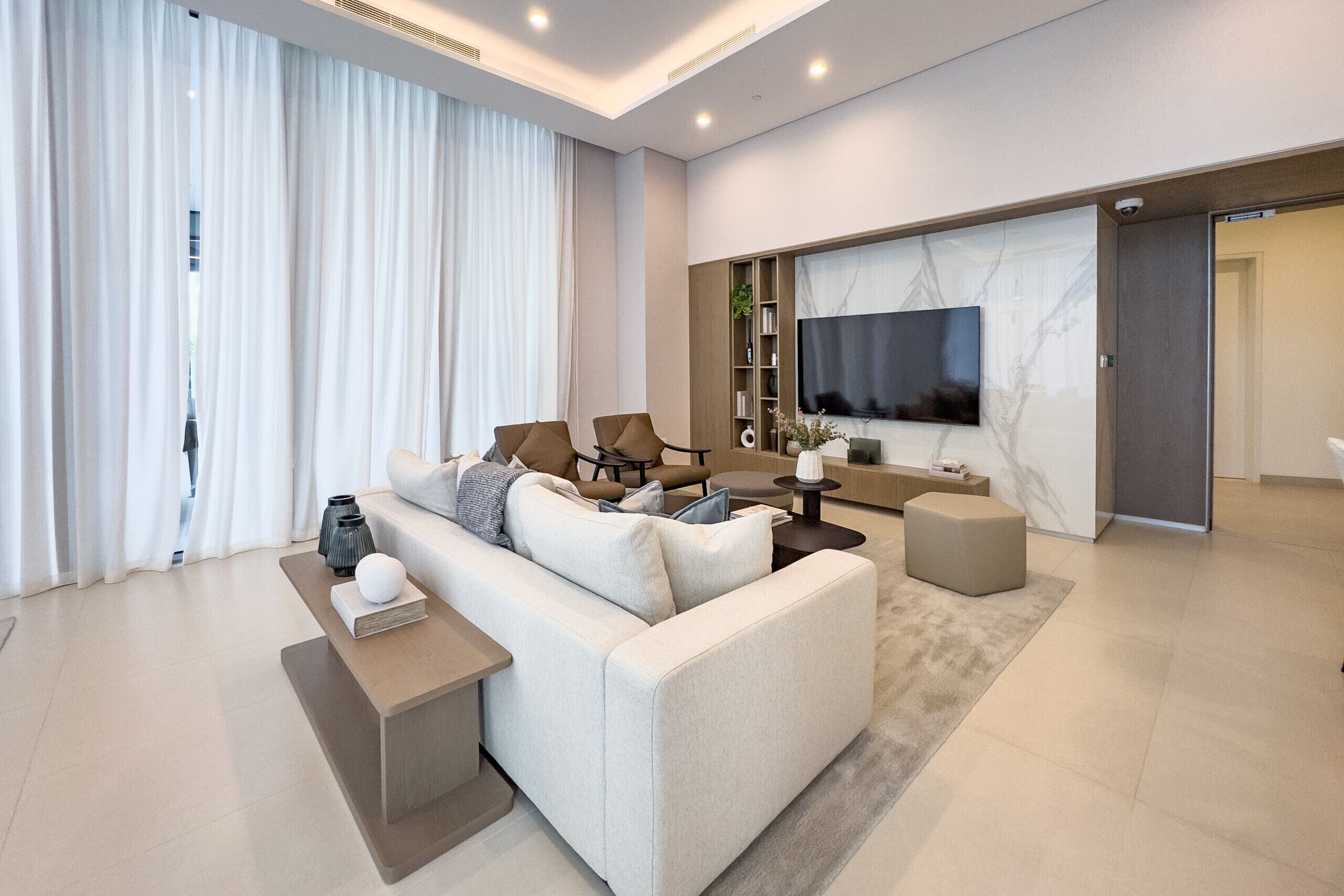 Una sala de estar moderna con sofá, mesa de centro y televisor.