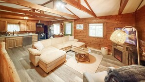 Een gezellig chaletinterieur met een zithoek, keuken en open haard.