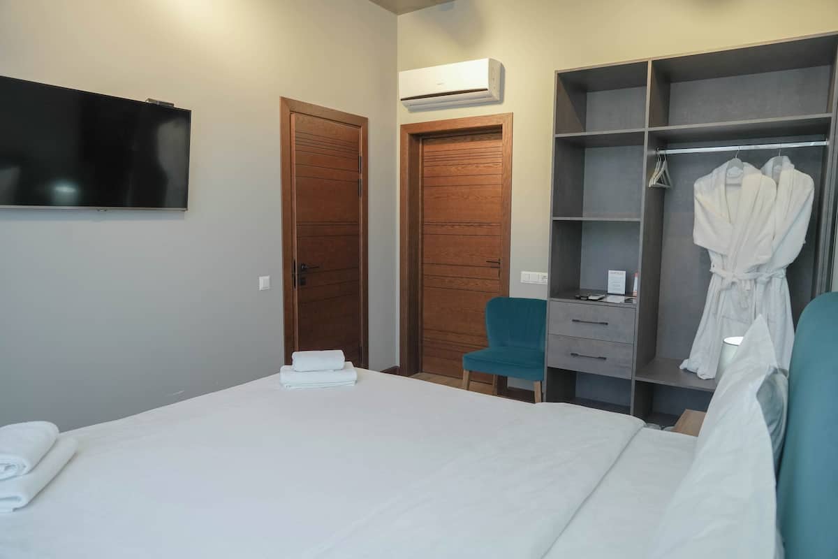 Une chambre d’hôtel équipée d’un lit, d’un bureau, d’une chaise, d’une armoire et d’un téléviseur.