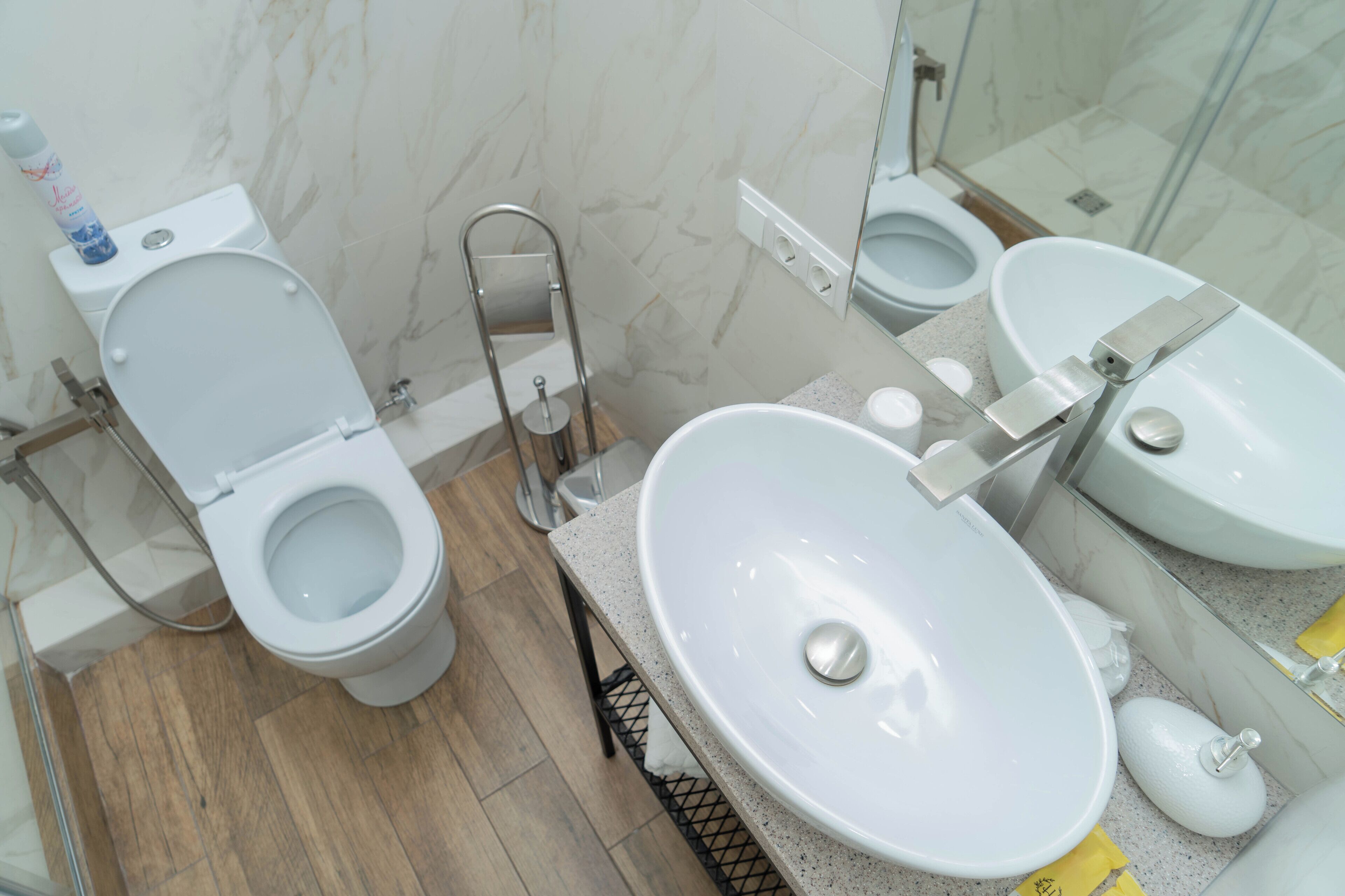 A modern bathroom with a toilet, bidet, and two sinks.