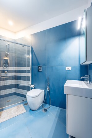 A modern bathroom with a shower, toilet, and sink. - Art Apartment by Napoliapartments (Naples)