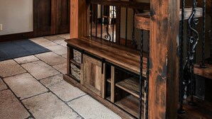 A wooden staircase with wrought iron railings, a stone-tiled floor, and a wooden door in the background. - Magique | Hot Tub & 360° St. Lawrence River View (Les Éboulements)