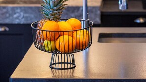 A kitchen counter with a fruit bowl containing a pineapple and oranges. - Appartements Hôtel & Spa Le Madeloc Collioure Centre (Collioure)