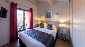 A bedroom with a bed, bedside tables, a window with curtains, a painting, and a view of the outside. - Appartements Hôtel & Spa Le Madeloc Collioure Centre (Collioure)
