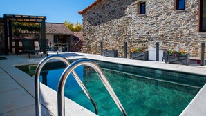 A stone building with a swimming pool, outdoor seating, and a pergola. - Country House 'Villa Jerusalém' with Mountain View, Wi-Fi & Air Conditioning (Romeu)