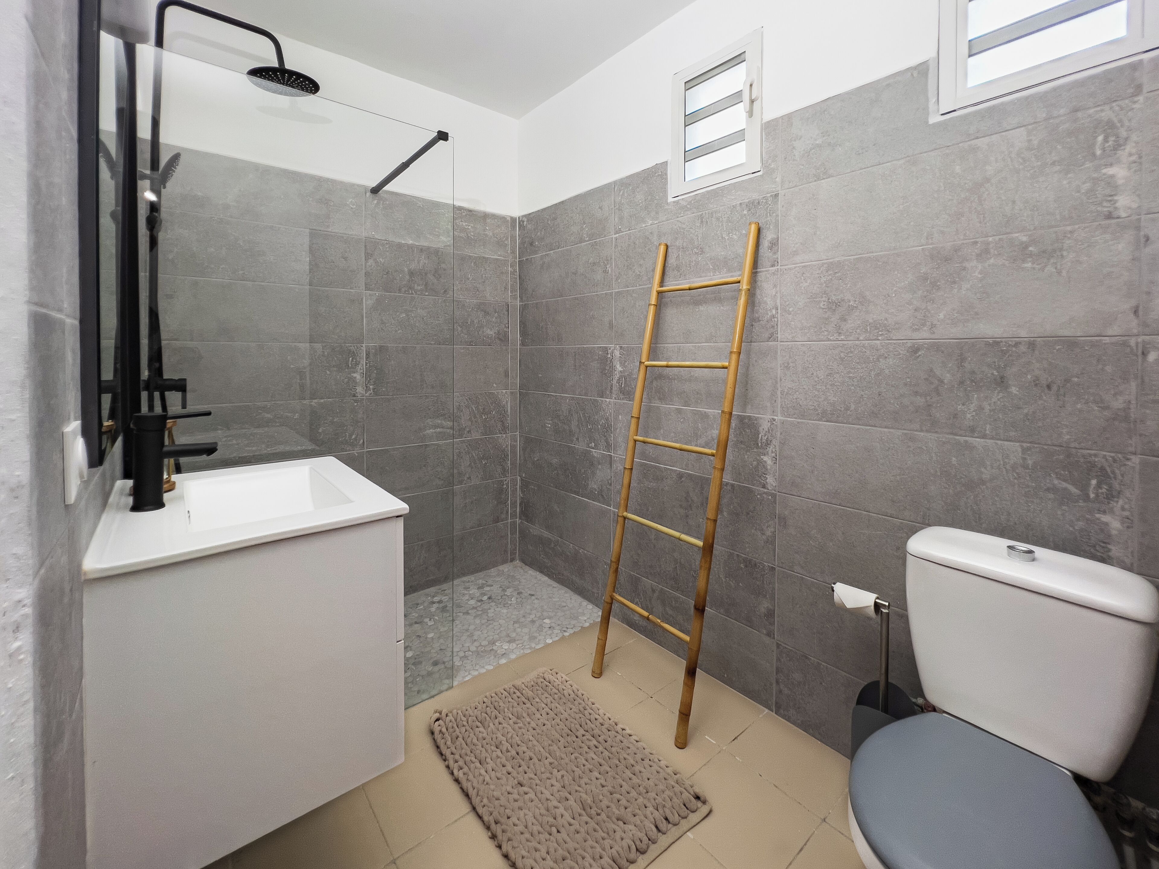 Ein Badezimmer mit Dusche, Toilette und Waschbecken.