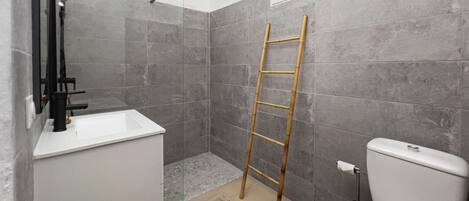 Ein Badezimmer mit Dusche, Toilette und Waschbecken.