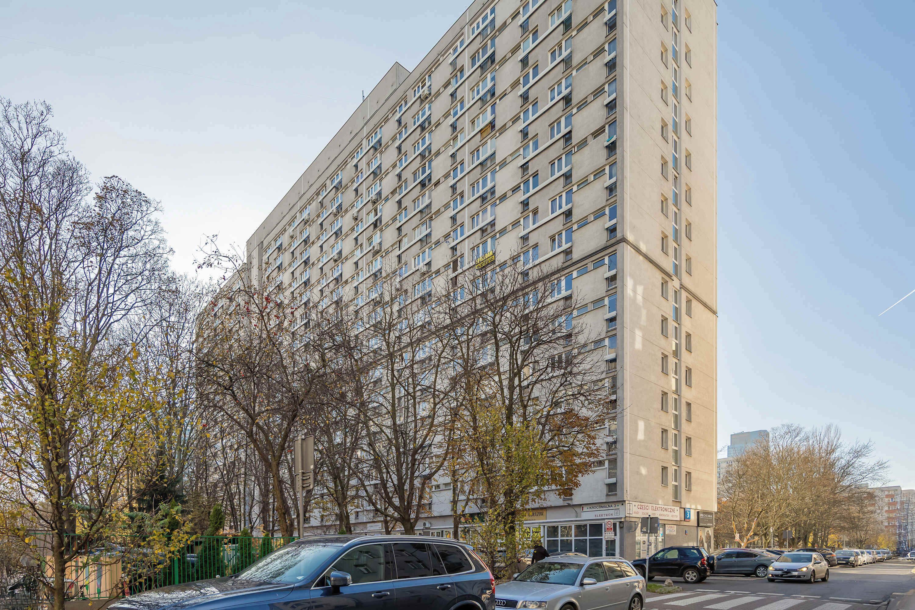 Un edificio residencial alto con varios pisos y balcones.