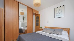 Una camera da letto con un letto, un'armadietto in legno e un quadro appeso al muro.