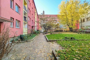 En sti der fører til et parkområde med bænke og en legeplads.