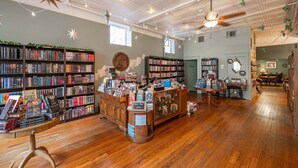 A bookstore with wooden floors, ceiling fans, and bookshelves filled with books. - The Washington Cottage - 6ppl (Harrison)