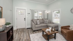 A modern living room with a sectional sofa, a coffee table, and a brown leather couch. - The Washington Cottage - 6ppl (Harrison)
