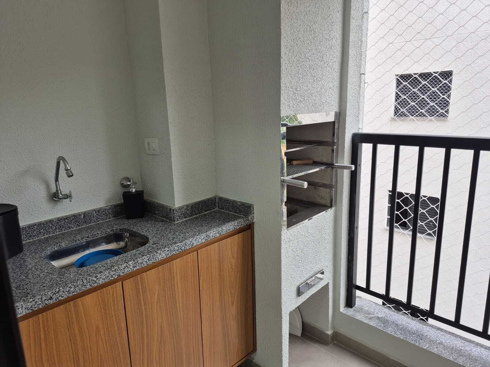 A bathroom with a granite countertop, a sink, and a wooden cabinet.
