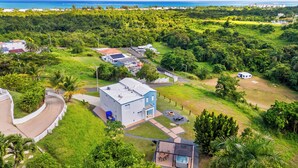 Ett stort, modernt hus med en rymlig trädgård, en bubbelpool och utsikt över havet.