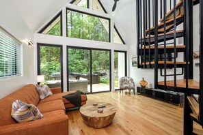 Una sala de estar moderna con un ventanal grande, una mesa de centro de madera y una estantería empotrada.