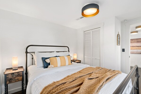 A bedroom with a bed, bedside tables, a wall-mounted light, and a closet. - Sunset Haven Dog-friendly Home Near Trails/lake (Fort Collins)