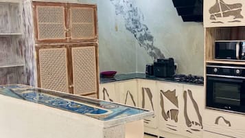 Een koelkast, kookgerei, borden en bestek