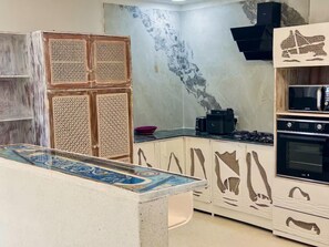 Een koelkast, kookgerei, borden en bestek