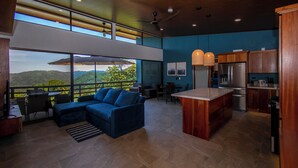 A modern kitchen with a large island, wooden cabinets, and a view of the outdoors. - 3-bedroom villa in Platanillo, ocean & mountain view! (Platanillo)